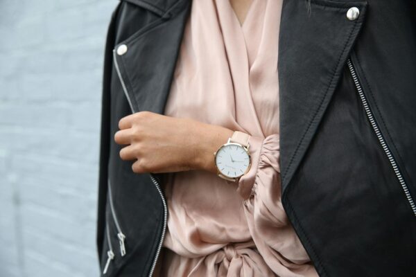 Stylish woman in a leather jacket showcasing an elegant wristwatch, perfect for fashion-forward individuals.